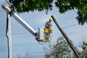 Wednesday, June 3, 2020 - A PSE&G worker cuts a power line connected to a pole that was tilted over after a tree fell on a house on Sanhican Drive during a severe storm blew through the are early in the afternoon.