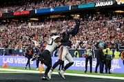 Chicago Bears wide receiver Keenan Allen (13), right, catches the ball to score a touchdown during the fourth quarter of an NFL football game at the Tottenham Hotspur stadium between the Jacksonville Jaguars and Chicago Bears in London, Sunday, Oct. 13, 2024.