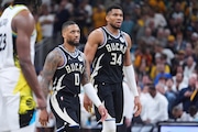 Milwaukee Bucks guard Damian Lillard (0) and forward Giannis Antetokounmpo (34) walk to the bench during the second half of a first-round NBA basketball playoff game against the Indiana Pacers in Indianapolis, Tuesday, April 22, 2025. (AP Photo/Michael Conroy)