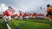 Hunterdon Central’s team enters the field with American Flags to honor first responders and veterans as Hunterdon Central football hosts Phillipsburg on Sept. 17, 2021