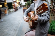 Unidentified Street Musician: Woman Playing Guitar on City Streets